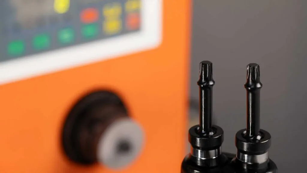 Close-up of Poplock black impact sockets designed for heavy-duty use, showing detailed craftsmanship on a drive, against a blurred background with an orange strip.
